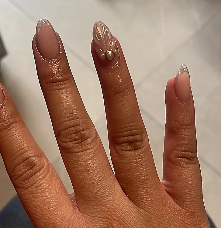 Uñas almendradas nude con punta francesa en cromo y una uña con concha de gel y perla dorada