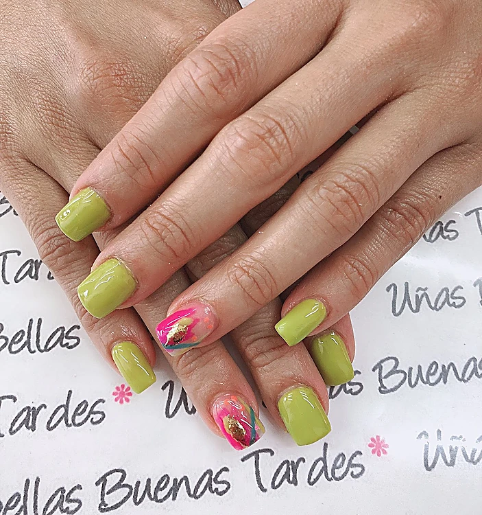 Manos cruzadas sobre el mantel con letra a mano, uñas cuadradas verde lima y una uña con acuarela fucsia y hoja de oro